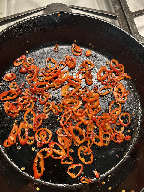 Charred Jimmy Nardello peppers in cast iron skillet